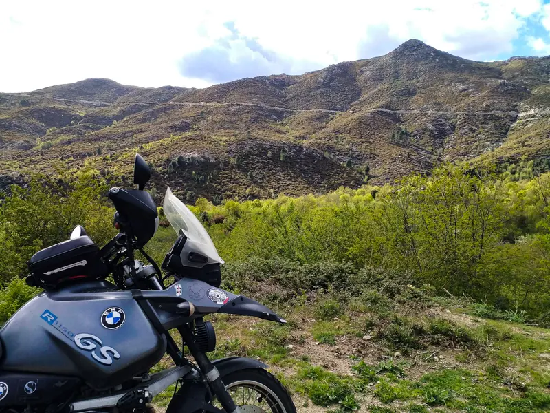 BMW GS overlooking mountain valley with green shrubs