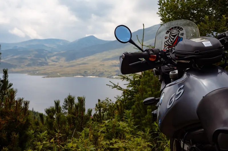 BMW GS detail with lake through pine trees